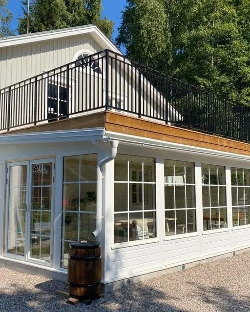 Inglasad tillbyggnad med spröjsade glaspartier mot trädgård